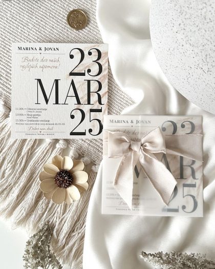 Pozivnica za venčanje sa omotom i puder roze satenskom mašnicom.
